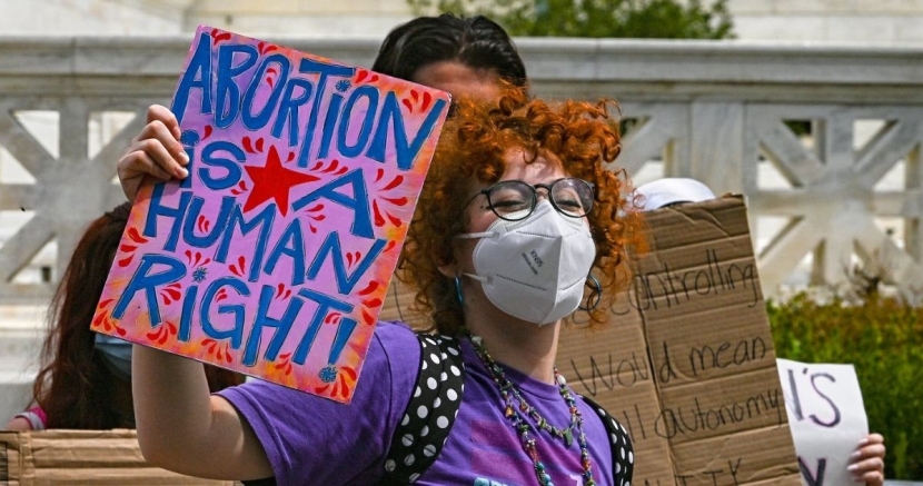 Protestor holding sign stating "Abortion Is A Human Right" Abortion_HumanRight
